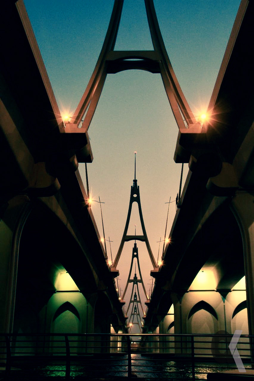 Symmetrical view down a modern cable-stayed bridge at dusk.